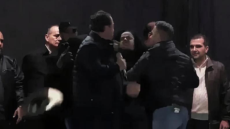 O deputado federal Rodolfo Nogueira (PL-MS), segurando o microfone, e a vereadora de Novo Mundo (MS) Eliete Feitosa (PT), sendo contida pelos outros homens do palco