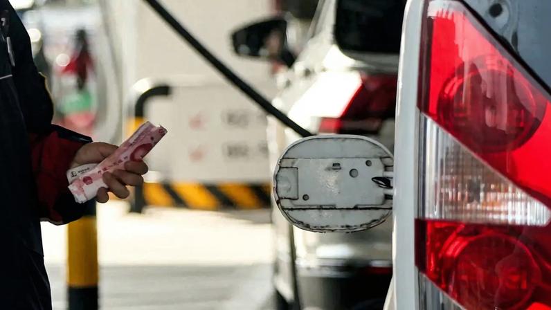 Funcionário segura notas de yuan em um posto de gasolina, antes de um anunciado aumento no preço, em Pequim, China - 22/03/2026 (Foto: REUTERS/Maxim Shemetov)