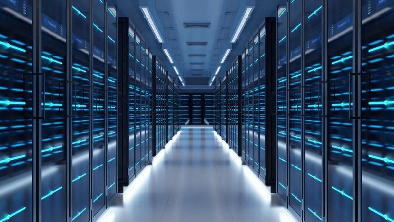 Corredor extenso de data center com racks de servidores iluminados em azul.