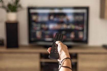 Pessoa ligando televisão para assistir streaming
