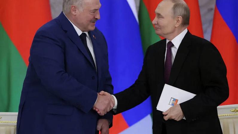 O presidente russo Vladimir Putin (à direita) cumprimenta o presidente bielorrusso Alexander Lukashenko