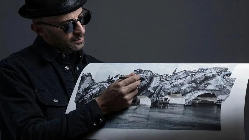 TOPSHOT - French photographer and street artist JR, poses in his Paris studio on November 26, 2025, presenting "The Cave of the Pont Neuf," the artwork he will create as a tribute to Christo and Jeanne-Claude, transforming the Pont Neuf forty years after the wrapping of Paris's oldest bridge. This work will be on display from June 6 to 28, 2026. (Photo by JOEL SAGET / AFP via Getty Images) / RESTRICTED TO EDITORIAL USE - MANDATORY MENTION OF THE ARTIST UPON PUBLICATION - TO ILLUSTRATE THE EVENT AS SPECIFIED IN THE CAPTION