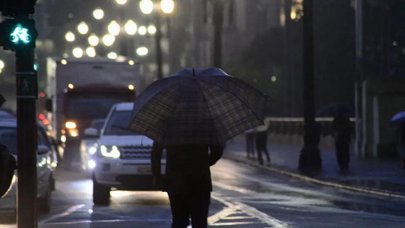 Pedestrians face rain in the old center of Sao Paulo, Brazil, on Thursday night during the summer. (Photo by Cris Faga/NurPhoto via Getty Images)