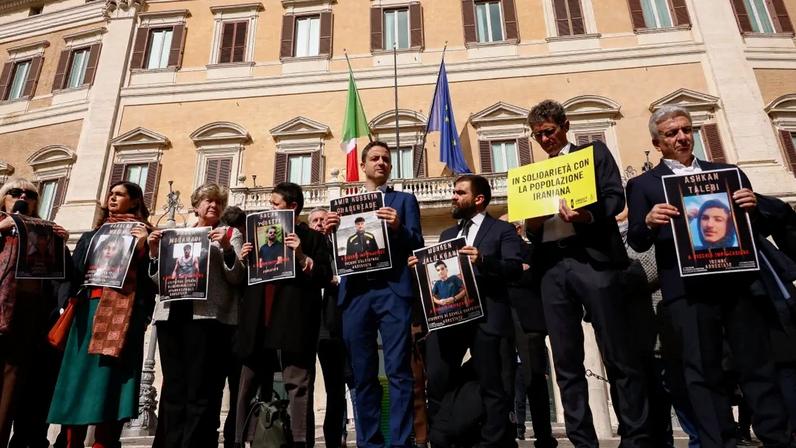 Dezenas de pessoas, incluindo vários parlamentares italianos, participam de um protesto relâmpago na Piazza Montecitorio em apoio aos prisioneiros iranianos e em oposição à pena de morte, em Roma, Itália, em 3 de março de 2026. Os manifestantes exibem retratos de detentos presos em prisões iranianas