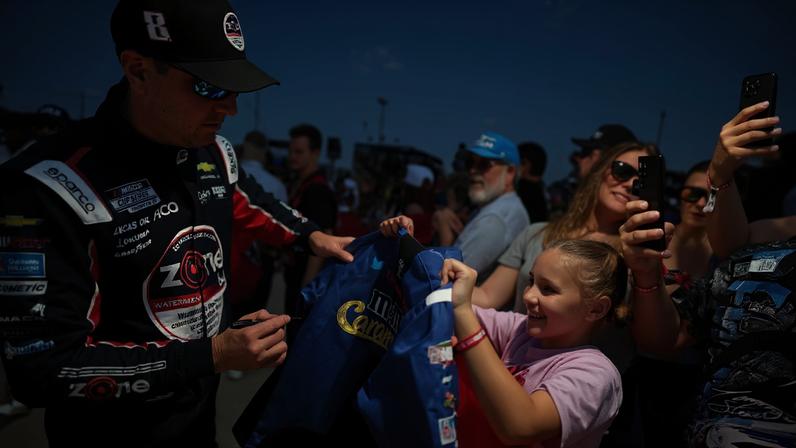 Kyle Busch, shown signing for a young fan earlier this month, died Thursday at 41.