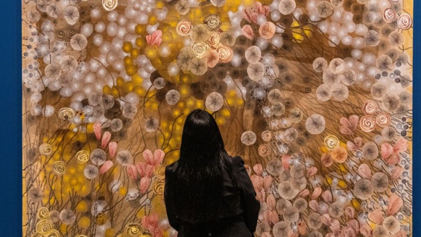 A woman gazes at a painting at the 2026 Venice Biennale.