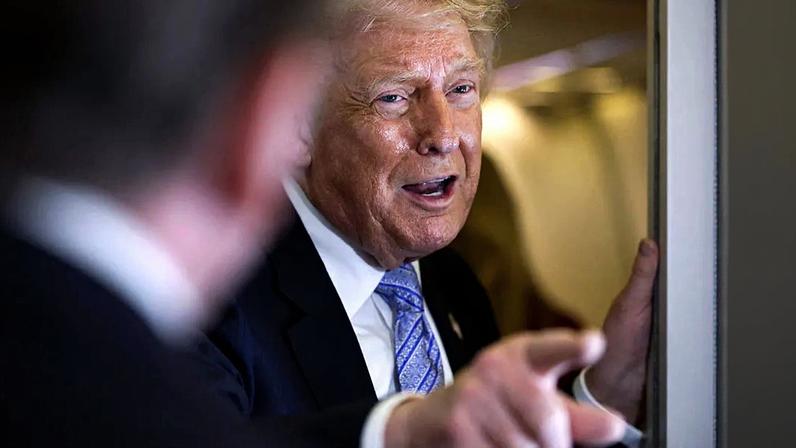 President Donald Trump, mid sentence, points while smirking.