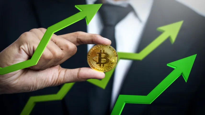 Homem segura moeda de bitcoin em meio a gráfico de alta