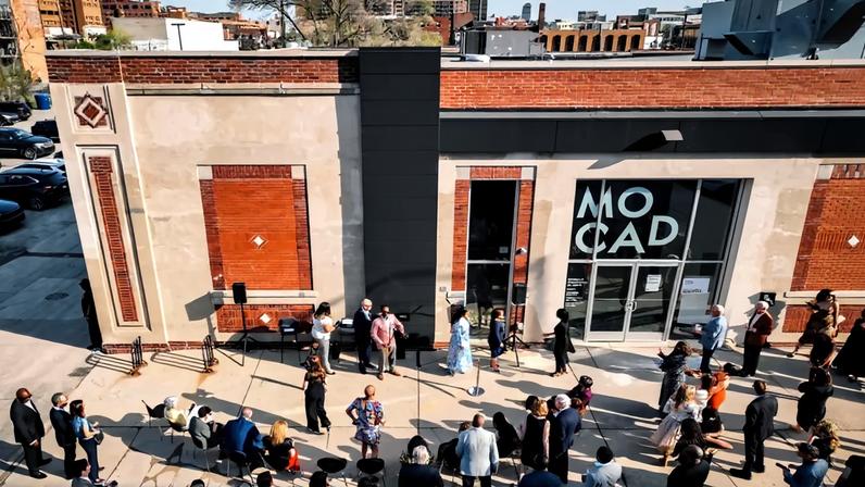 Aerial view of the exterior of MOCAD with people gathered outside ahead of a ribbon cutting.