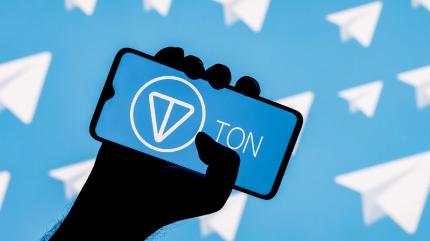 Ilustração de mão segurando smartphone com logotipo da Toncoin