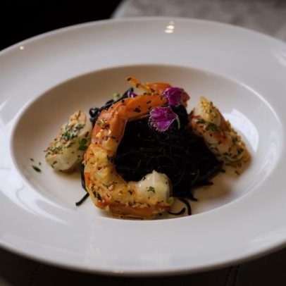 Espaguete al nero com camarões e fonduta de queijo brasileiro trufada