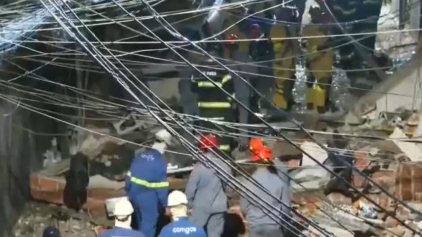 Funcionários da Comgás e bombeiros circulam entre os destroços na área da explosão.