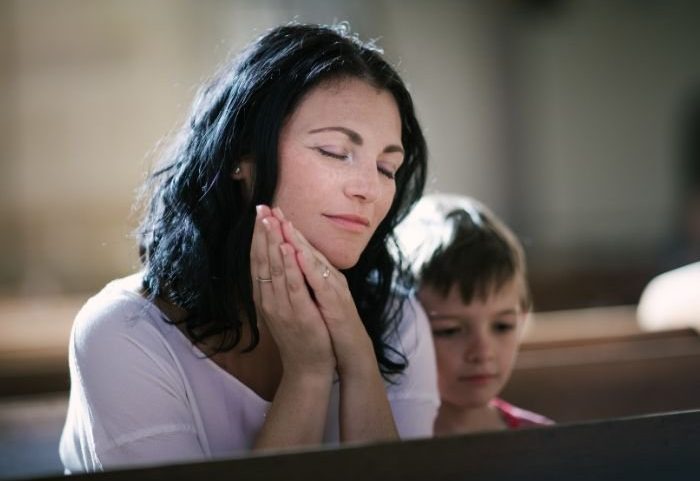 Mãe e filho em uma igreja (Foto: Canva Pro)