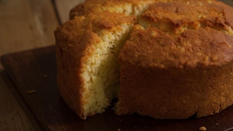 Bolo de tapioca fatiado sobre uma mesa de madeira. Foto: Roberto Seba/Estadão