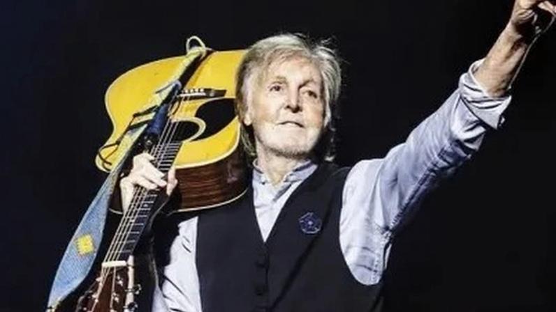 Paul McCartney. Ele está segurando um veículo