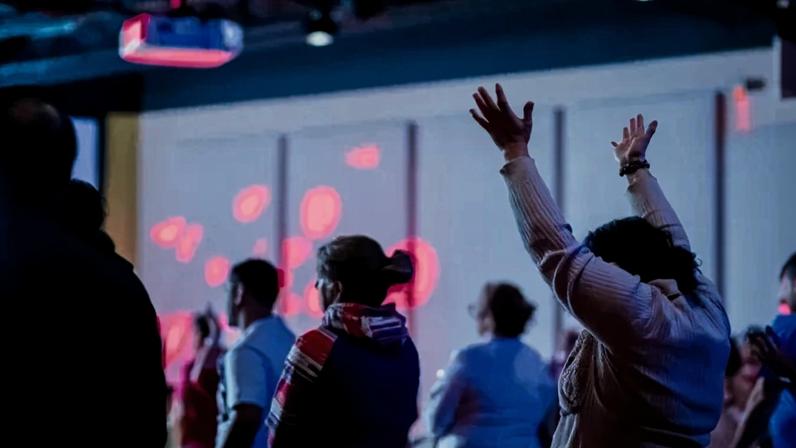 Pessoas louvando durante culto em igreja (Foto: Canva Pro)