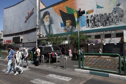 Pessoas passam por um mural que retrata o falecido líder supremo do Irã, aiatolá Ali Khamenei, em Teerã, 25 de maio de 2026