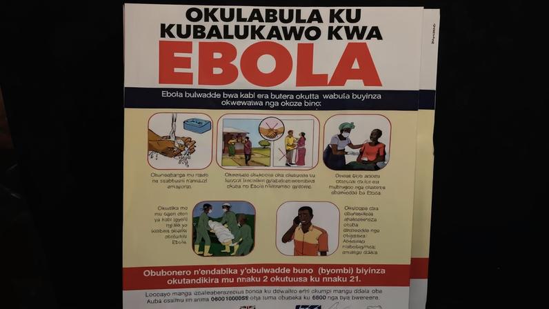 Cartaz com números de contato de emergência do ebola em uma tenda na passagem de fronteira de Busunga, entre Uganda e a República Democrática do Congo