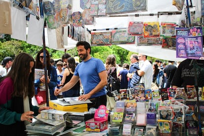 Javier atiende a una familia en su puesto de JFandCards del Rastro de Madrid, el 3 de mayo de 2026.
