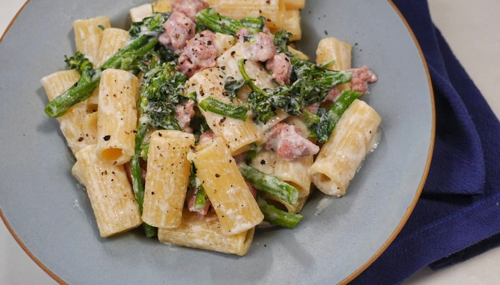 Rigatoni com linguiça e brócolis em prato de cerâmica azul, por baixo, pano de mesa azul