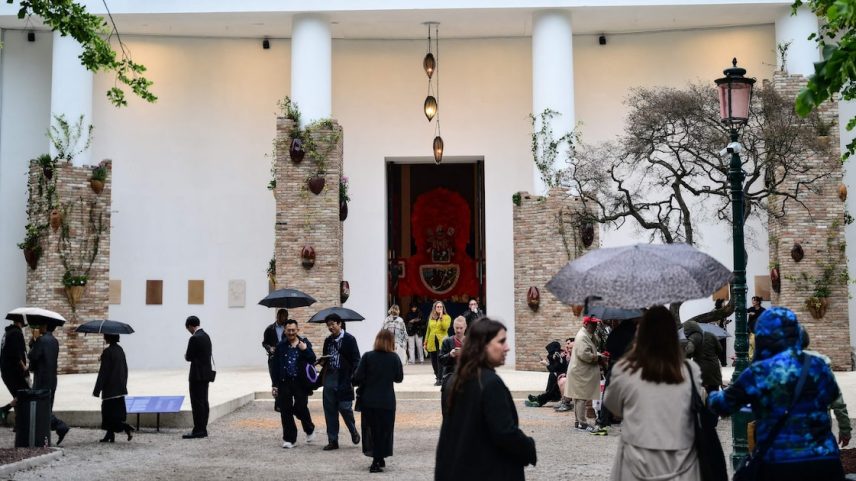 Pessoas caminham próximo ao pavilhão que abriga a exposição 'In Minor Keys', com curadoria da curadora de arte camaronesa-suíça Koyo Kouoh, durante a prévia para a imprensa da 61ª Bienal de Arte de Veneza, em Veneza, no dia 5 de maio de 2026.