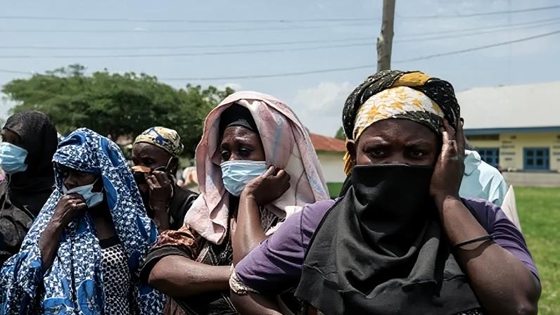Uma mulher senta-se ao lado de um parente que se acredita ter morrido de Ebola no Hospital Geral de Referência de Mongbwalu, na província de Ituri, República Democrática do Congo, em 20 de maio