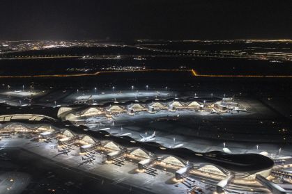 Vista aérea panorâmica noturna da janela de um avião em decolagem do novo Terminal A do Aeroporto Internacional Zayed (AUH), também conhecido como Aeroporto Internacional de Abu Dhabi