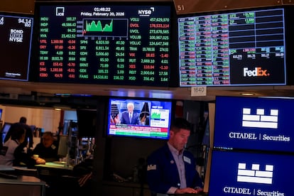 Operadores en la Bolsa de Nueva York junto a una televisión con la imagen de Donald Trump, presidente de EE UU.