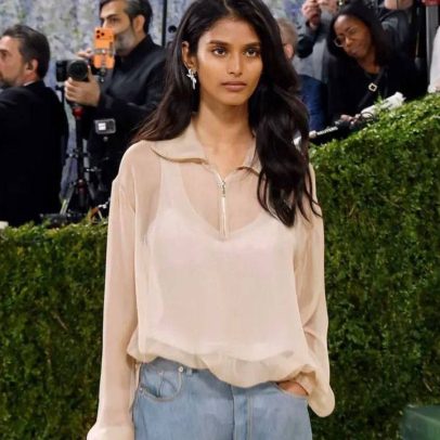 Modelo usa jeans e suéter no tapete vermelho do Met Gala