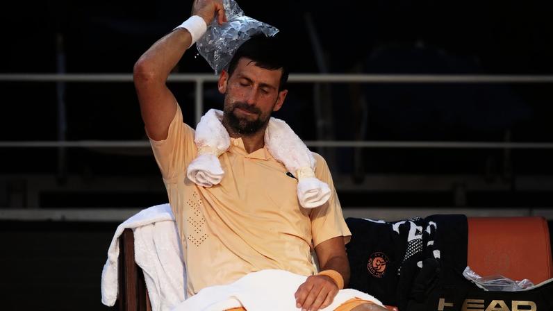 Novak Djokovic of Serbia uses a bag of ice to cool down during a change of ends in his Men's...