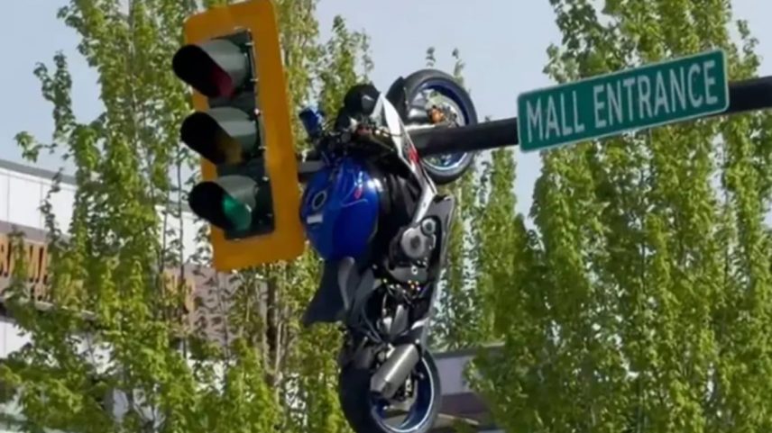 Moto decola e fica presa no poste do semáforo após colisão com um carro