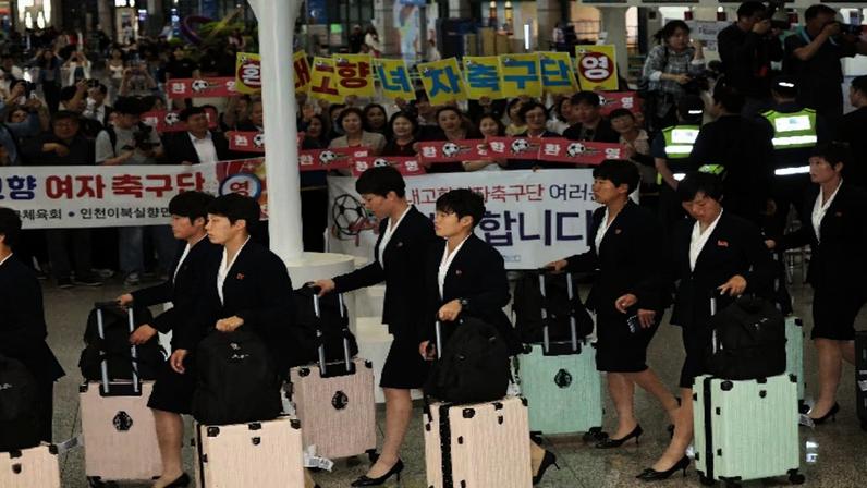 Membros do clube de futebol norte-coreano Naegohyang Women's FC passam por ativistas que os aplaudem enquanto chegam ao Aeroporto Internacional de Incheon para uma partida contra o Suwon FC Women da Coreia do Sul em 20 de maio, em Incheon, Coreia do Sul, em 17 de maio de 2026. REUTERS/Kim Hong-Ji