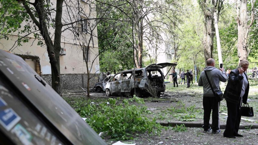 Moradores observam carros destruídos após um ataque aéreo russo em Odessa, na Ucrânia, nesta quarta-feira, 13.