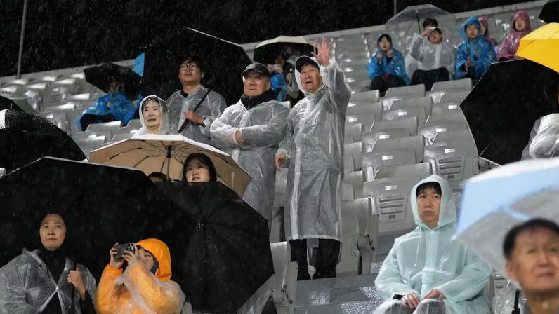 Chung Kyung-jo, ao centro, acenando, apoia a equipe visitante na partida entre duas equipes coreanas, em Suwon, Coreia do Sul, na quarta-feira, 20 de maio de 2026