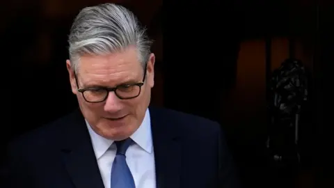 PA Media Sir Keir Starmer looks down, with a black background