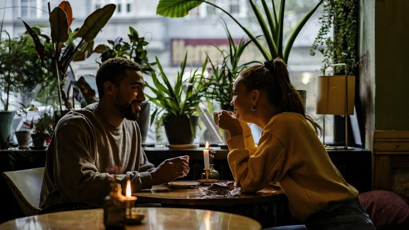 Casal jantando juntos em um restaurante ou cafeteria. Metrópoles