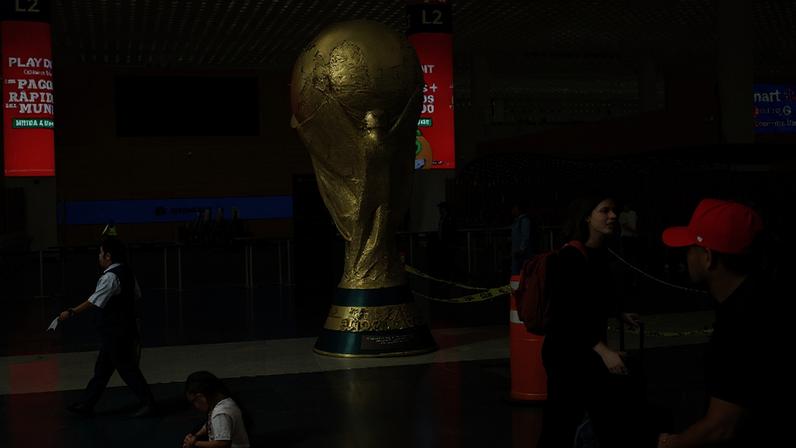 Passageiros passam por réplica gigante do troféu da Copa do Mundo no Aeroporto Internacional da Cidade do México 18 de maio de 2026 REUTERS/Henry Romero