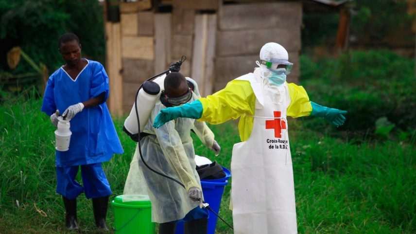 Um profissional de saúde borrifa desinfetante em um colega após trabalhar em um centro de tratamento de Ebola em Beni, no leste da República Democrática do Congo, em 9 de setembro de 2018