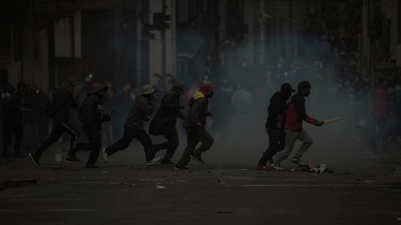 Manifestantes atravessam correndo uma rua durante um protesto antigovernamental em La Paz, Bolívia, na segunda-feira, 18 de maio de 2026 — Foto: AP/Freddy Barragan