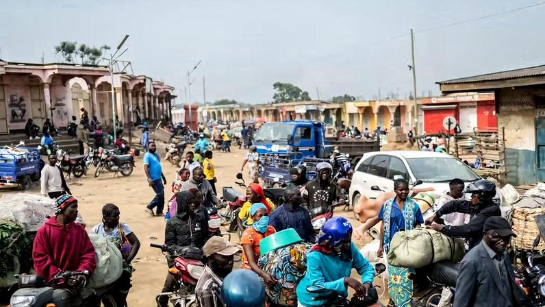 Mototaxistas e seus passageiros aguardam na entrada do mercado central enquanto equipes de saneamento desinfetam a área, em meio ao combate ao surto de Ebola na província de Ituri, em Bunia, Congo, no sábado, 23 de maio de 2026. — Foto: AP/Moses Sawasawa