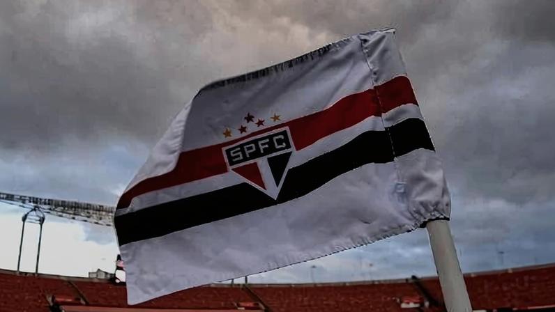 Bandeira do São Paulo tremula no escanteio do gramado do Morumbi, sob nuvens negras
