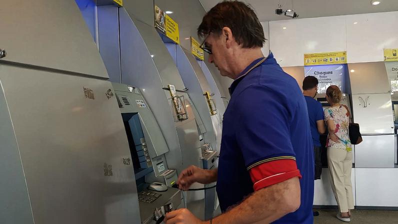 Bolsonaro no caixa eletrônico de uma agência bancária