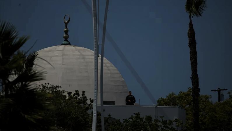 An officer standing near the mosque's dome