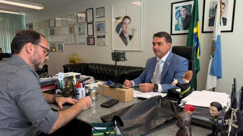 Mensagens atribuídas a Flávio (esq.) indicam pedido de dinheiro a Vorcaro para financiar filme sobre a trajetória do ex-presidente Jair Bolsonaro; na foto, o senador ao lado de Carlos (dir.)