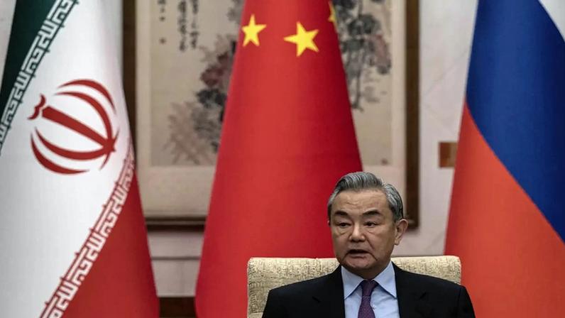 O chanceler Wang Yi, da China, à frente das bandeiras de seu país, da Rússia e do Irã, durante encontro entre as partes em 2025. (Foto: EFE/EPA/GETTY IMAGES/POOL)