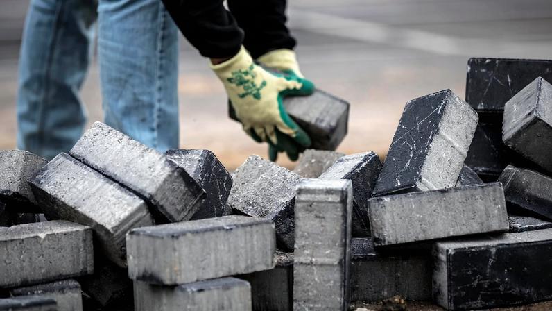 Imagem ilustrativa de homem com bloco de concreto