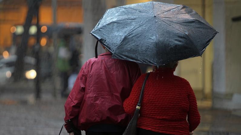 Pedestres se protegem do frio e da chuva em BH