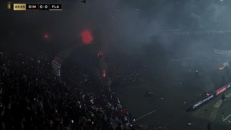 Torcedores do Independiente Medellín ateiam fogo nas arquibancadas do estádio Atanásio Girardot durante o jogo contra o Flamengo