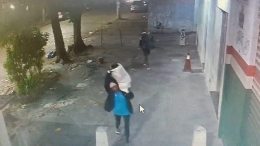 Imagem colorida,criminosos saindo com sacos lotados de suprimentos da creche - Metrópoles