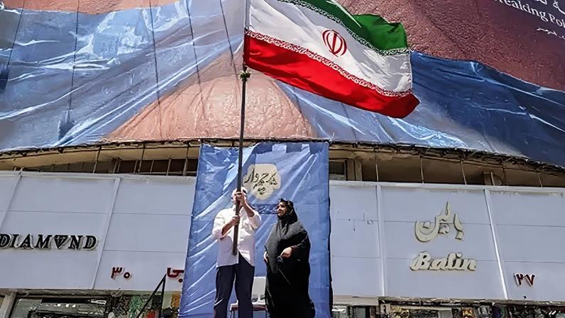 Getty Images People hold up an Iranian flag in Tehran
